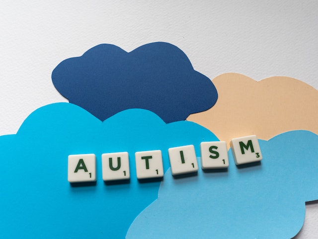 Autism spelt out in tiles laid on paper cut-out clouds